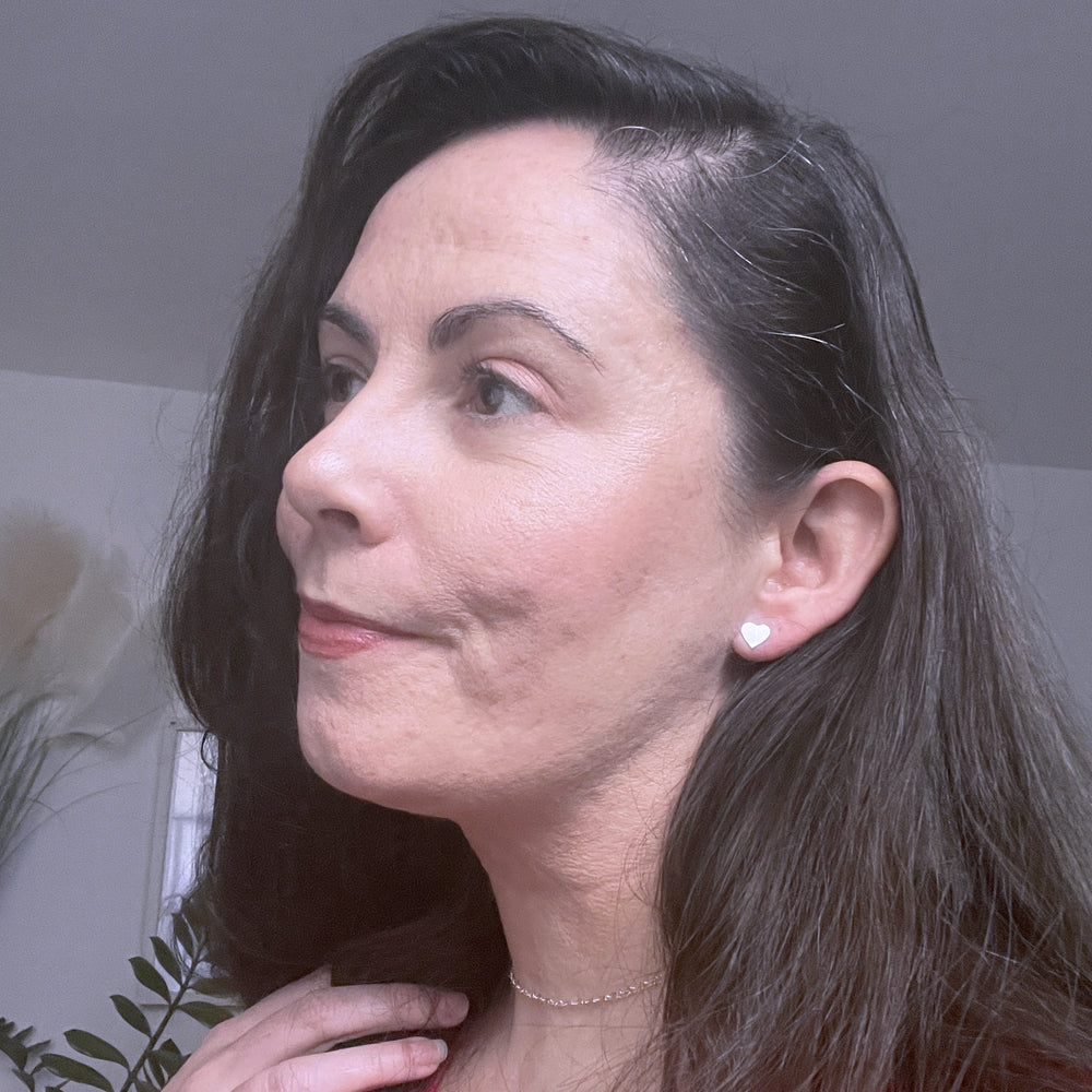Picture of Elise wearing silver Amora heart shaped studs and heart chain