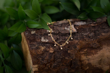 Gold-fill chain bracelet in a wooded scene
