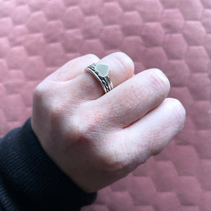Vida heart ring and beau ring stacked together on ring finger of hand in a fist 
