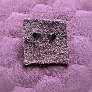 Close up on amora heart studs on leather square