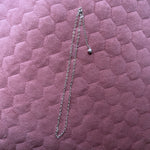 chain made of heart shapes connected together, lying on pink cushioned background