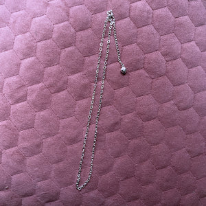 chain made of heart shapes connected together, lying on pink cushioned background